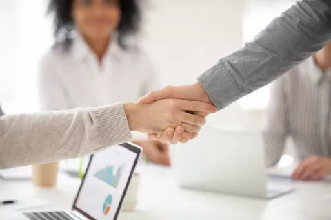 deux personnes qui se prennent la main pour signifier un accord ou une aide