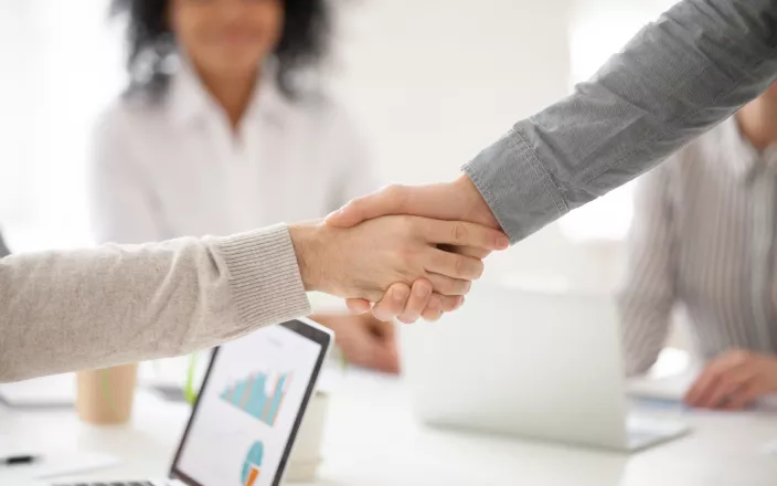 deux personnes qui se prennent la main pour signifier un accord ou une aide