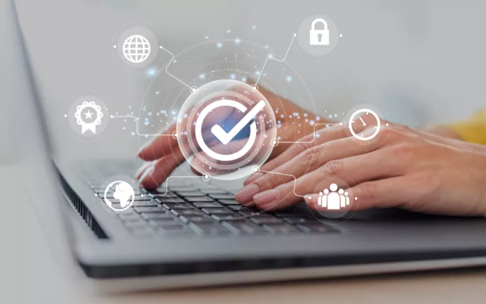 Cybercésurité : mains qui tapotent sur un ordinateur avec des symboles de cybersécurité