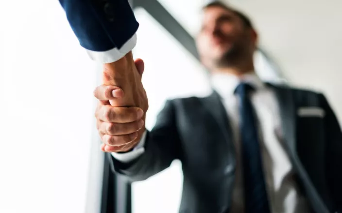 poignée de main entre personnes en costumes