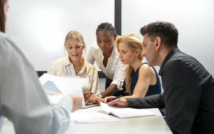 Plusieurs personnes d'origine ethnique différente travaillent ensemble autour d'une table