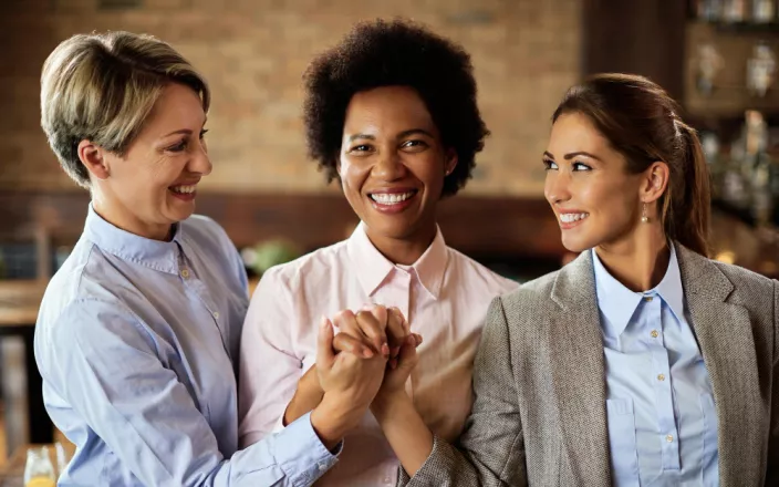 3 femmes qui se serrent la main