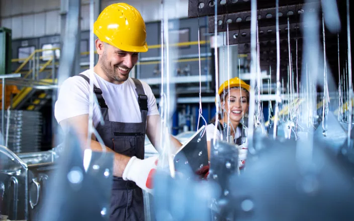 Un homme et une femme avec un casque dans une usine