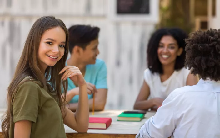 4 étudiants autour d'une table d'origine ethnique diverse