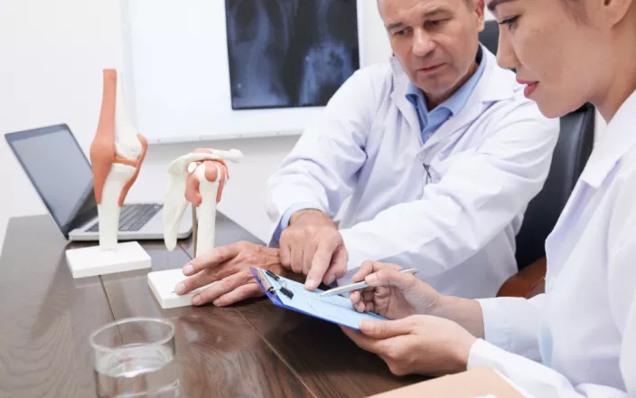 deux chercheurs en train de discuter autour de la problématique de l'arthrose du genou