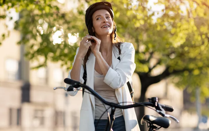 femme sur un vélo électrique en train de mettre son casque