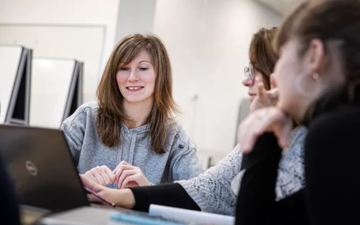 Groupe d'étudiants en train de discuter autour d'une table