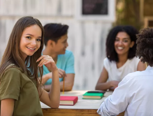 4 étudiants autour d'une table d'origine ethnique diverse