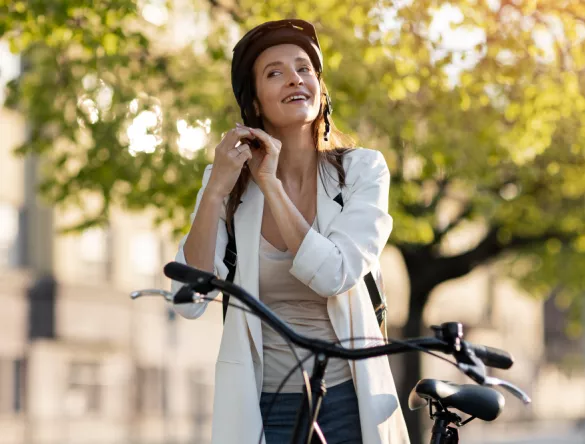 femme sur un vélo électrique en train de mettre son casque
