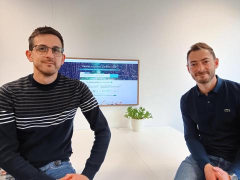 Portrait des deux fondateurs de Resalib assis sur une table devant un écran présentant leur solution Resalib