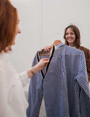 Photo entreprise L'adaptelier avec la co-fondatrice qui tient une chemise bleue adaptée
